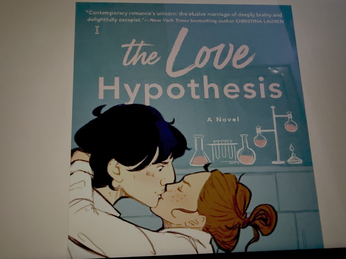 The Love Hypothesis book cover by Ali Hazelwood showing two lab researchers in an intimate moment with chemistry equipment in the background